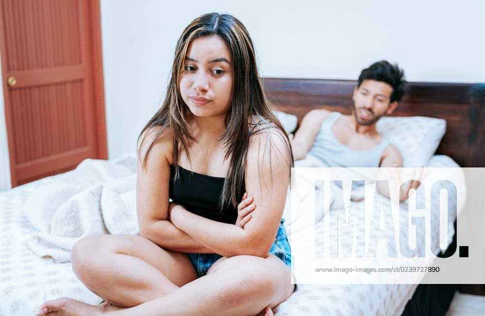 Ehefrau streitet sich mit ihrem Mann im Bett. Junges Paar streitet sich auf dem Bett sitzend. Konzept der Paar Probleme im Bett. Aufgeregte Frau mit Ehemann auf dem Bett sitzend
