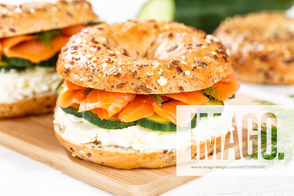 Bagel Brötchen Sandwich zum Frühstück belegt mit Lachs Fisch auf einem Brett in Stuttgart, Deutschland Stuttgart, Deutschland - 15. März 2023: Bagel Brötchen Sandwich zum Frühstück belegt mit Lachs Fisch auf einem Brett in Stuttgart, Deutschland.