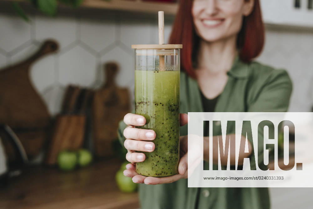 Woman showing smoothie in kitchen at home model released, Symbolfoto property released, YTF00565