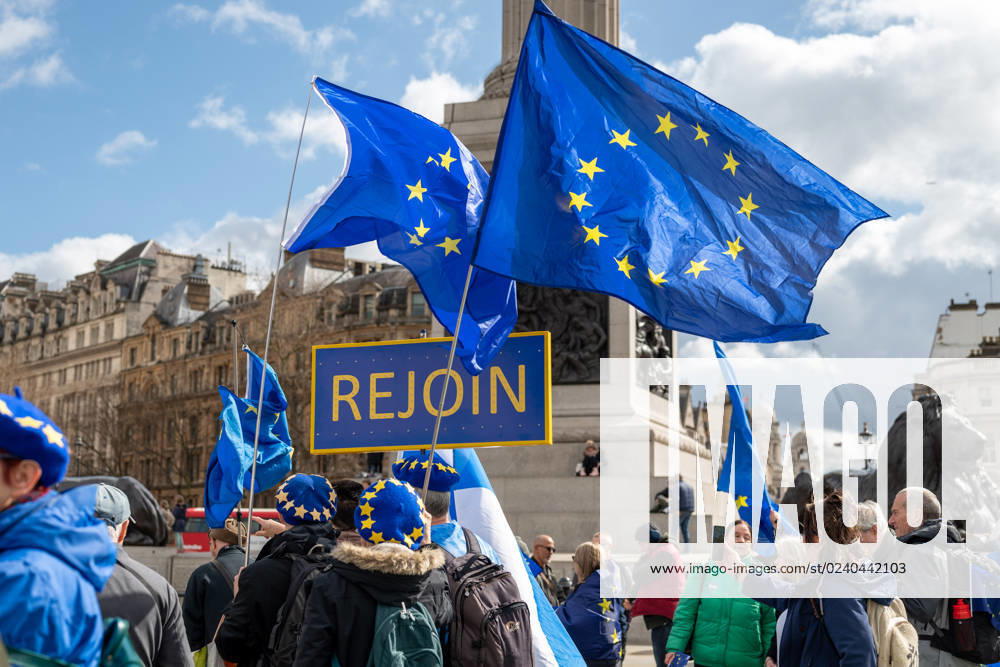 Activists hold European flags and a placard saying REJOIN in Trafalgar Square during the demonstration. The National Rejoin March (NRM) demonstration took place in Central London. NRM is a direct action campaign group to get the UK to Rejoin the EU. London United Kingdom - ZUMAs197 20230325_zaa_s197_029