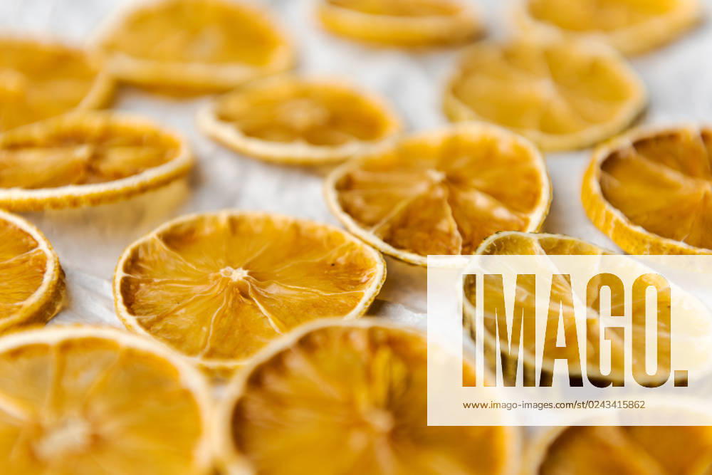 Slices of dried lemon lying on white paper Slices of dried lemon lying on white paper