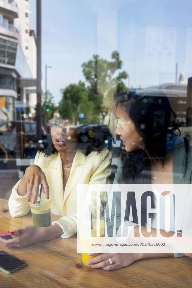 Friends talking to each other sitting in cafe seen through window model released, Symbolfoto property released, MMPF00703