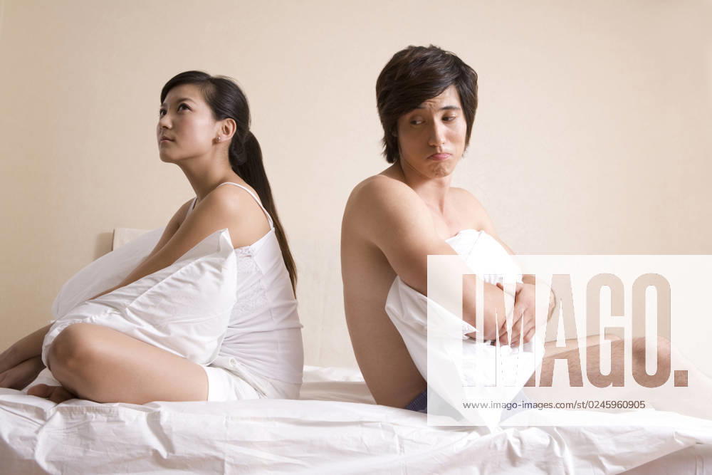 Chinese couple sitting on bed Beijing China
