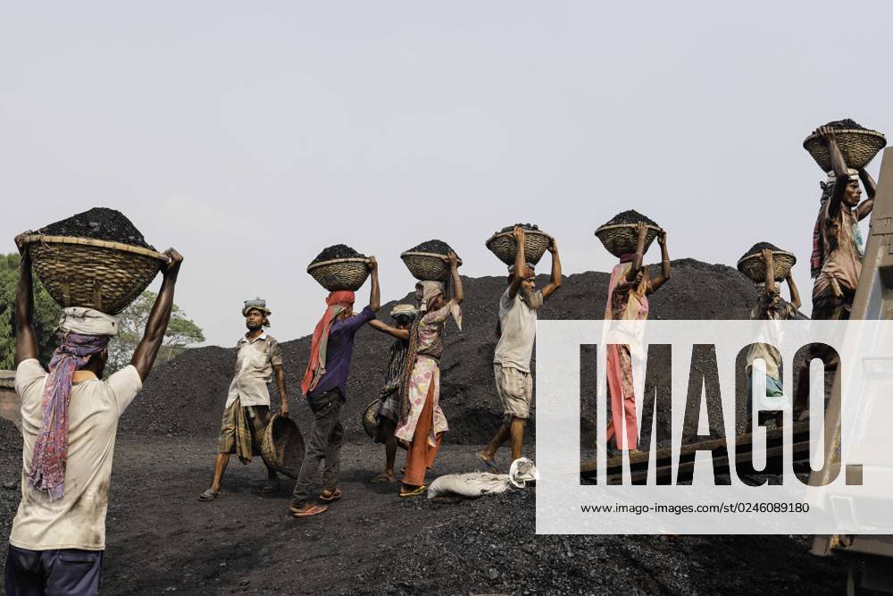 Labourers transport baskets full of coal on the top of their heads as they unload coal from a cargo ship in Gabtoli, on the outskirts of Dhaka, Bangladesh on April 29, 2023. About 3.0 per cent of the countrys power currently comes from coal. Workers earn USD $4 to $6 per day. Dhaka Bangladesh - ZUMAh355 20230429_zip_h355_005