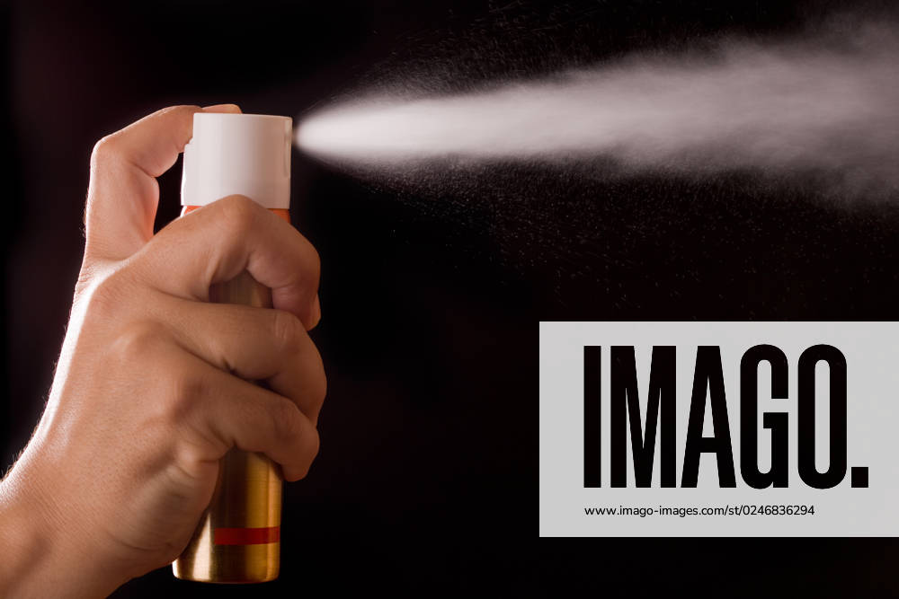 Aerosol can spraying on black background