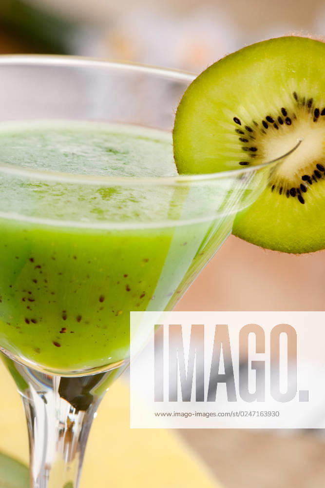 A tasty kiwi smoothie in a natural setting with macro detail on kiwi slice
