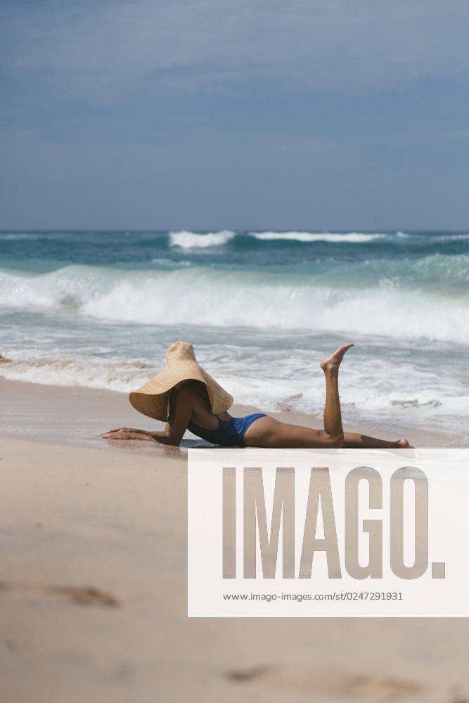 Young woman in a big straw hat on the ocean. Maldive Village, Anse Etoile, Seychelles CR_YUKI230216CF-1129395-01 ,model released, Symbolfoto