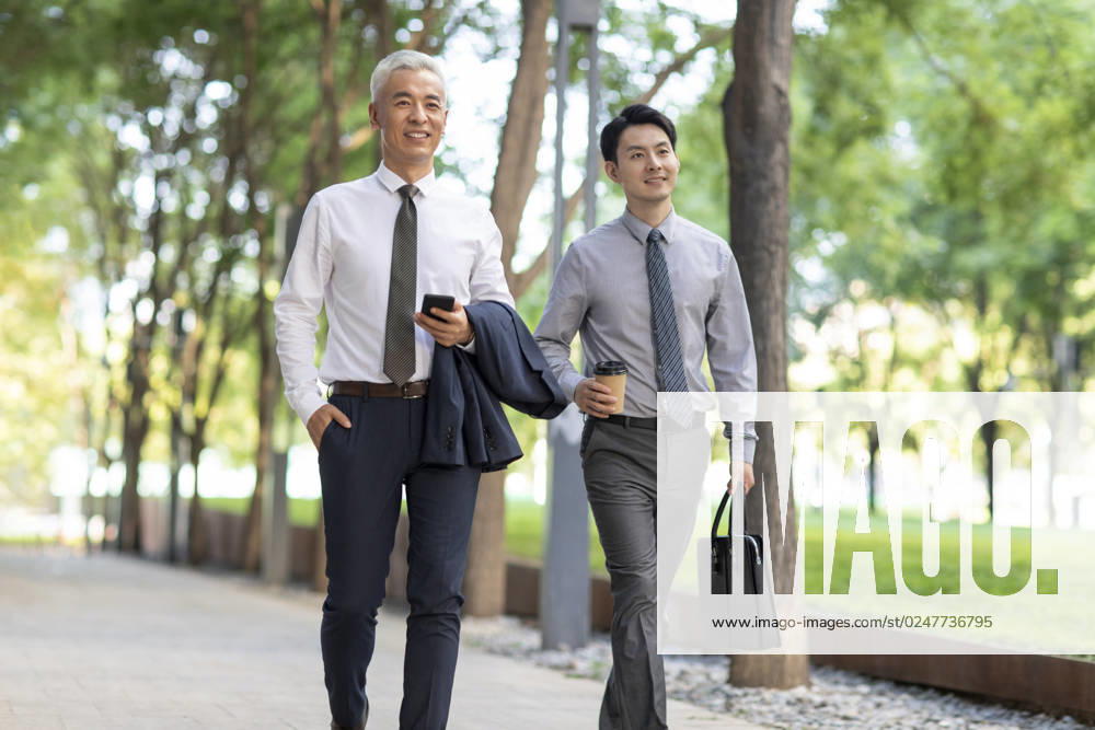 Confident Chinese business people walking outdoors Beijing China