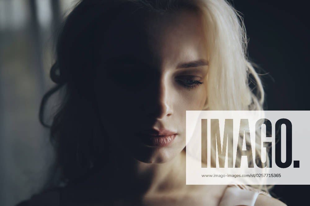 Depressed blond woman in darkroom model released, Symbolfoto, AZF00519