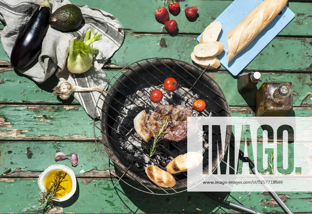 Meat, tomatoes and baguette slices cooking on barbecue grill property released, HHF05876