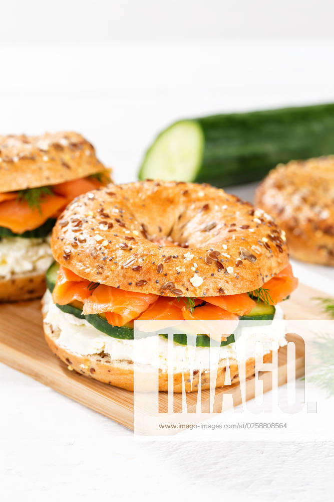 Bagel Brötchen Sandwich zum Frühstück belegt mit Lachs Fisch auf einem Brett Hochformat in Stuttgart, Deutschland Stuttgart, Deutschland - 15. März 2023: Bagel Brötchen Sandwich zum Frühstück belegt mit Lachs Fisch auf einem Brett Hochformat in Stuttgart, Deutschland.