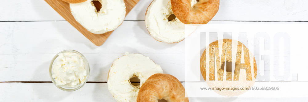 Bagel Brötchen Sandwich zum Frühstück belegt mit Frischkäse auf Holzbrett von oben Panorama in Stuttgart, Deutschland Stuttgart, Deutschland - 18. März 2023: Bagel Brötchen Sandwich zum Frühstück belegt mit Frischkäse auf Holzbrett von oben Panorama in Stuttgart, Deutschland.