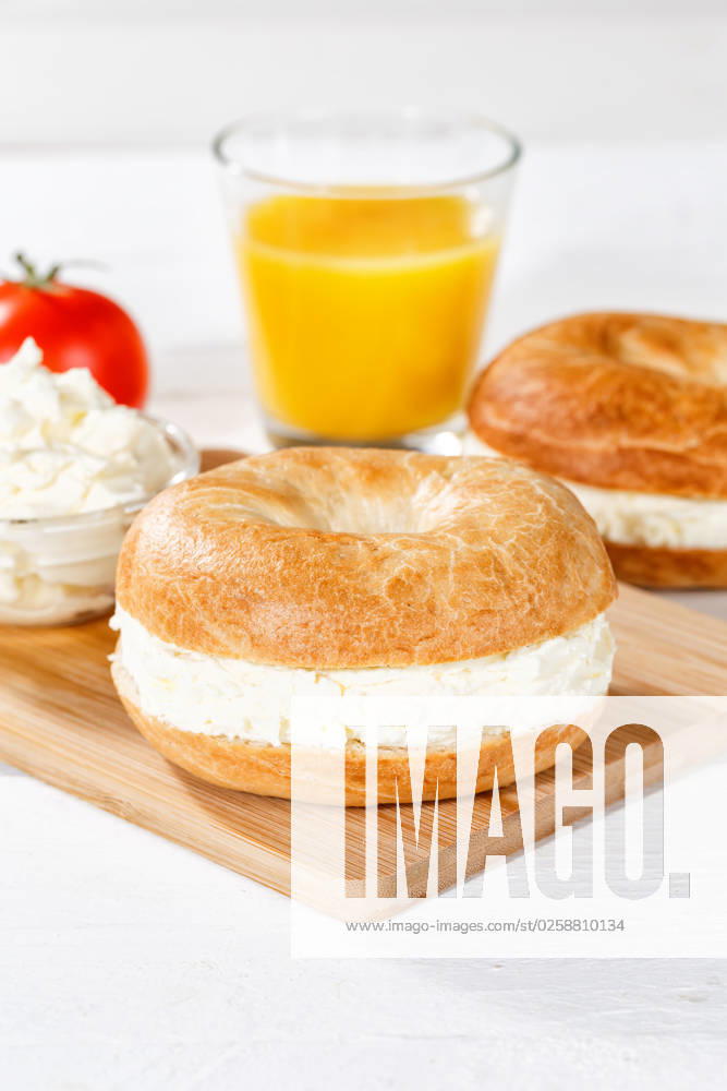 Bagel Brötchen Sandwich zum Frühstück belegt mit Frischkäse Hochformat in Stuttgart, Deutschland Stuttgart, Deutschland - 18. März 2023: Bagel Brötchen Sandwich zum Frühstück belegt mit Frischkäse Hochformat in Stuttgart, Deutschland.