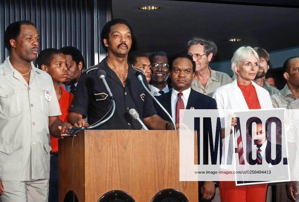 The Reverend Jesse Jackson flanked by DC Mayor Marion Barry (L) and Delegate Walter Faunroy (D-DC) (R) Frances (Sissy) Farenthold (holding portrait of Jackson ) speaking at news conference inside Dulles International Airport shortly after landing on his return from Havana, Cuba with freed American and Cuban prisoners said that he was convinced peace was possible in Central America. Dulles US - ZUMAr142 19840628_zap_r142_005
