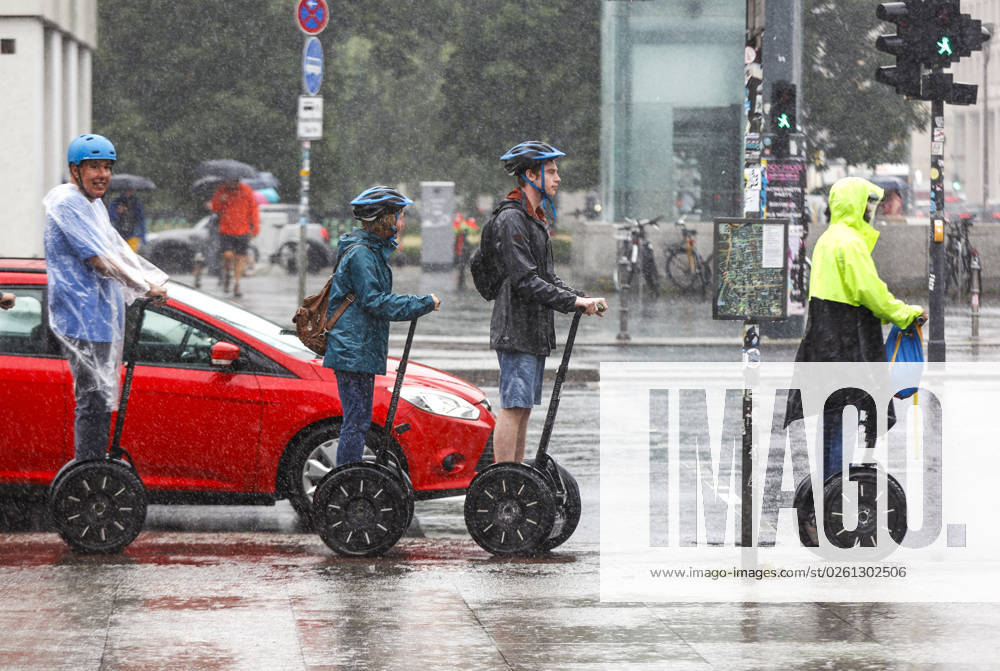 -Touristen stehen bei starken Regen mit Segway Personal Transportern an einer Ampel. Starke Unwetter sind ueber Teile Deutschlands gezogen. Berlin Berlin Deutschland