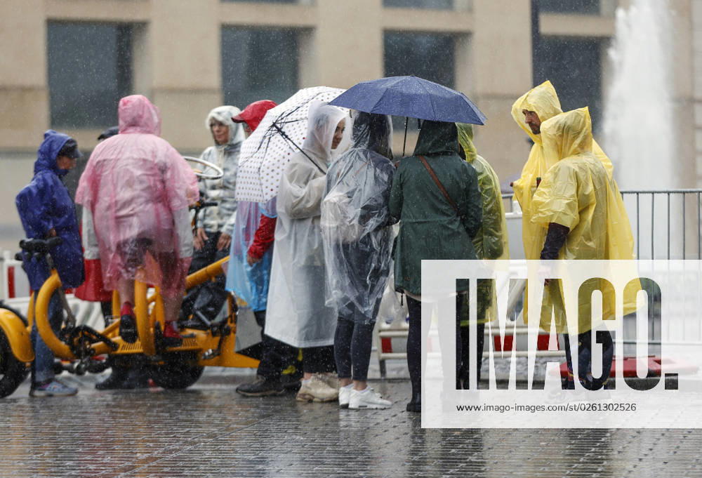 -Touristen schuetzen sich mit Regencapes und Regenschirmen vor starkem Regenfall. Starke Unwetter sind ueber Teile Deutschlands gezogen. Berlin Berlin Deutschland