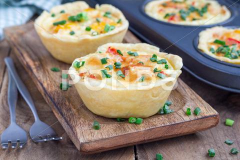Mini quiche with chicken and bell pepper on a wooden plate appetizer, baked, bel, breakfast, brunch, cheese, chicken, closeup, cook, cream, dairy, delicious, dinner, dish, dough, easy, eat, egg, food, french, golden, healthy, herb, homemade, ingredient, kitchen, lorraine, lunch, meal, meat, mini, muffin, novel, onion, paprika, party, pepper, picnic, pie, plate, protein, quiche, savory, serving, small, snack, starter, table, tasty, wooden