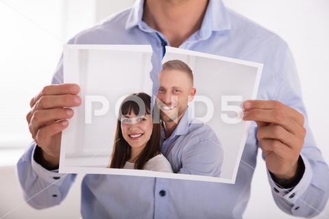 Close-up Of A Man's Hand Tearing Photo Of Smiling Couple In Two Pieces photo, couple, ex, up, break, boyfriend, sad, bed, man, tension, pictures, tear, smile, divorce, past, home, room, memory, image, print, house, picture, romantic, heartbreak, people, disappointed, sofa, conflict, problem, women, hug, person, holding, page, standing, together, young, husband, relationship, wife, casual, love, separation, male, lovers, breakup, photograph, human, beautiful