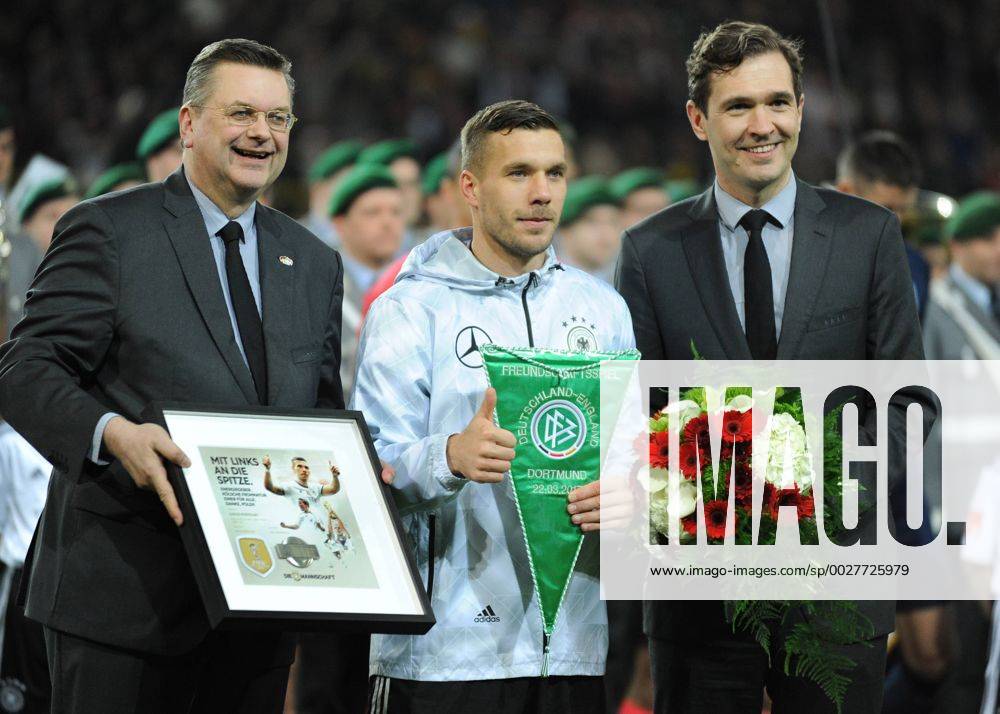 Fußball-Länderspiel: Deutschland - England 22.03.2017 in Dortmund. Lukas Podolski (Deut.) wird vom DFB geehrt. Li: DFB-Präsident Reinhard Grindel. Re: DFB-Generalsekretär Dr. Friedrich Curtius. HM
