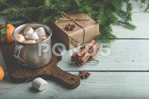 Hot chocolate with marshmallows and Christmas gift on wooden table cinnamon, dessert, anise, metal mug, beverage, table, xmas, background, orange, tangerine, hot chocolate, celebration, christmas, food and drink, wrapped, cocoa, rustic, present, cinnamon stick, citrus, cup, holiday, winter, gift, copy space, christmastime, chocolate, gift box, craft paper, food, fir, surprise, cutting board, still life, christmas decorations, drink, hot drinks, warm, new year, delight, cozy, mandarine, decoration, wooden, green, marshmallow, fruit, star anise, spruce branch