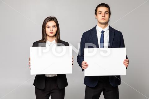 Confident business couple standing with blank board to advertise or invite on white background background, woman, business, hand, love, person, girl, couple, man, school, banner, paper, young, isolated, space, happy, blank, showing, board, female, male, casual, studio, smile, presentation, white, billboard, guy, job, feeling, portrait, work, copy, together, posing, surprised, product, caucasian, camera, boyfriend, relationship, romantic, expression, presenting, adult, gesture, two, people, message, invitation