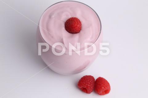 A high angle shot of an organic yogurt smoothie with raspberries on white background yogurt, raspberry, organic, fruit, diet, smoothie, berry, sweet, healthy, food, drink, dessert, strawberry, breakfast, glass, background, health, blueberry, fresh, summer, pink, detox, blended, refreshment, freshness, lifestyle, snack, closeup, vegetarian, delicious, white
