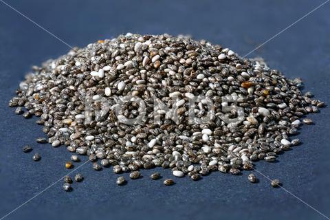 A macro shot of chia seeds in detail against a black background seed, food, seeds, grain, natural, detail, raw, dry, macro, healthy, chia, organic, closeup, background, diet, crop, vegetarian, nutrition, ingredient, close, details, chiaseed, chiaseeds, dark, surface