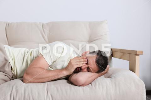 Sleepy man lying on sofa at home adult,background,beige,caucasian,copy,couch,deprivation,deprived,disorder,early,exhausted,exhaustion,eyes,fatigue,health,home,indoors,insomnia,lazy,lifestyle,lying,male,man,morning,person,problem,sickness,sleep,sleepless,sleeplessness,sleepy,sofa,space,text,tired,tiredness,unhappy,unhealthy,unproductive,weekend