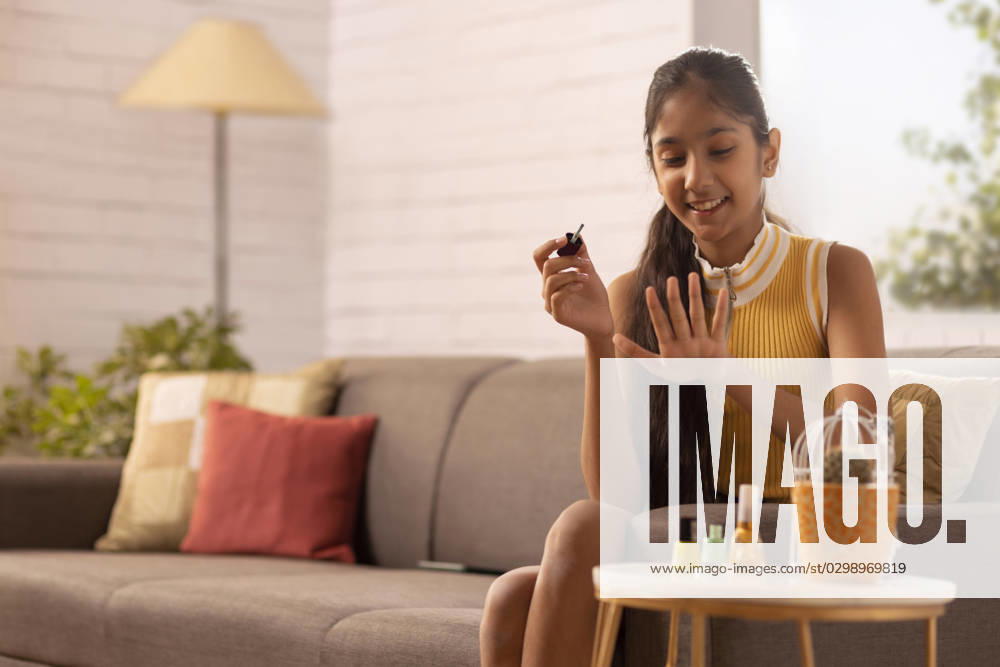 Tween girl painting her finger nails