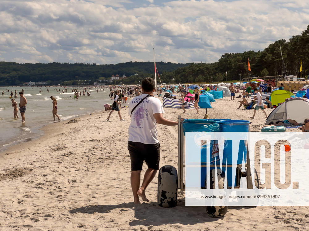 Blick auf den Strand von Binz auf der Insel Rügen in Mecklenburg-Vorpommern. Ein Mann schiebt einen Eiswagen vor sich her. Binz ist das größte Seebad auf der Insel Rügen. Die Gemeinde gehört zum Landkreis Vorpommern-Rügen in Mecklenburg-Vorpommern. Das Ostseebad trägt seinen Titel seit 1885 und ist Anziehungspunkt und Urlaubsort für Alle, die Natur, Strand und Entspannung lieben. Binz Ostsee Mecklenburg-Vorpommern Deutschland