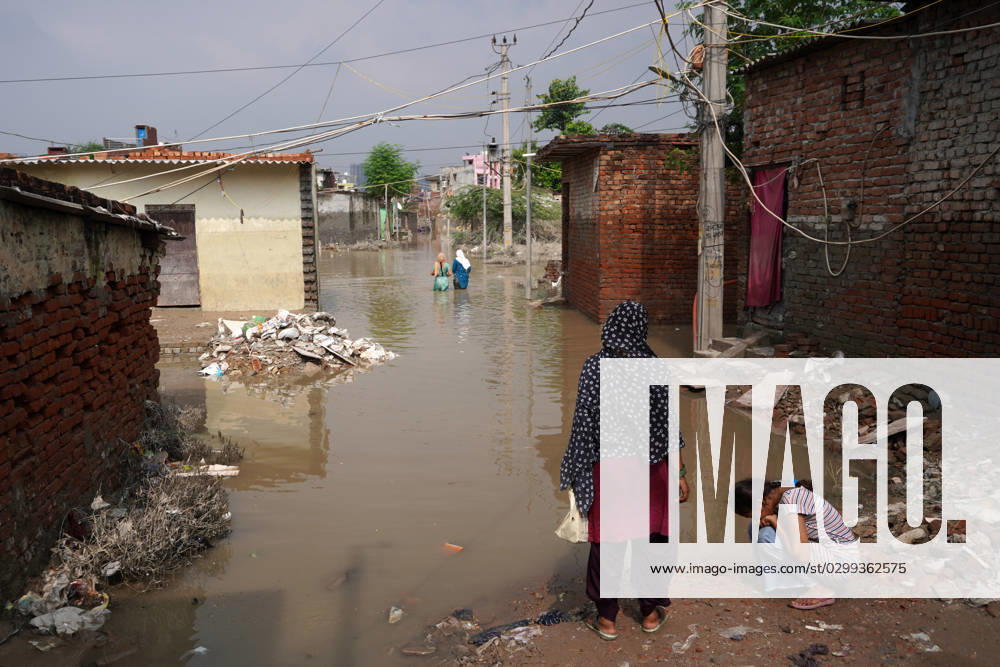 INDIA-FLOODS Residents wade through a waterlogged street to reach their homes in a low-lying area, after a rise in the waters of river Yamuna due to heavy monsoon rains, in New Delhi on July 16, 2023. New Delhi India