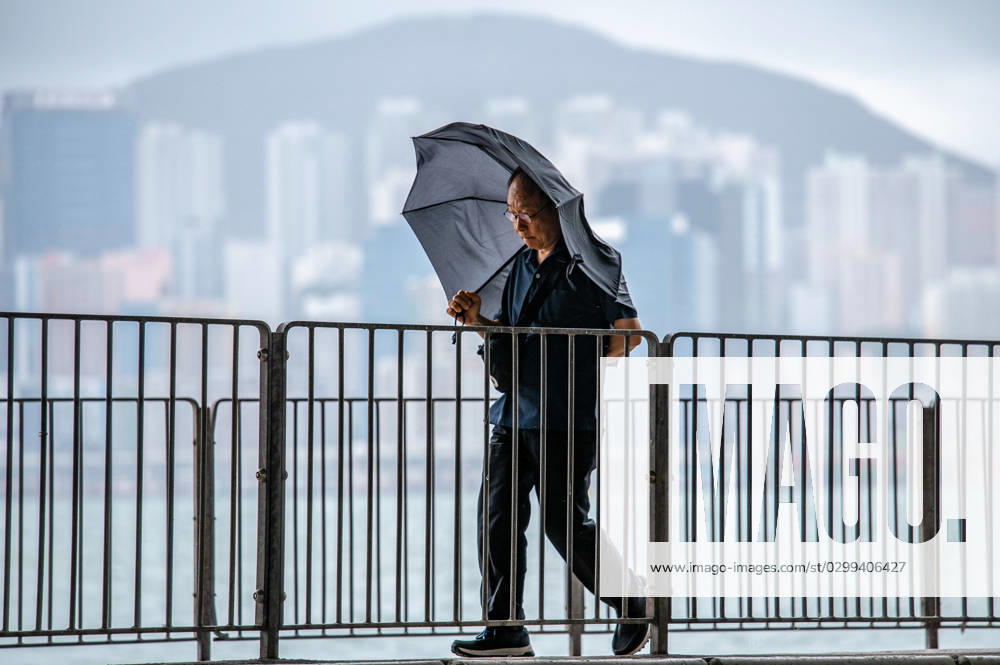 A man enveloped by his umbrella as he strolls along the waterfront during Typhoon Talim in Hong Kong. This was the first typhoon of the year and the HK Observatory issued the Number 8 Signal, effectively shutting down the city. Hong Kong China - ZUMAs197 20230717_zaa_s197_009