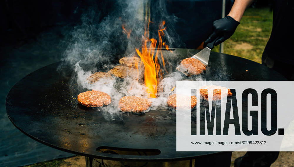 Preparing juicy beef hamburger patties . BBQ meat sizzling over hot flames. Preparing juicy beef hamburger patties . BBQ meat sizzling over hot flames.