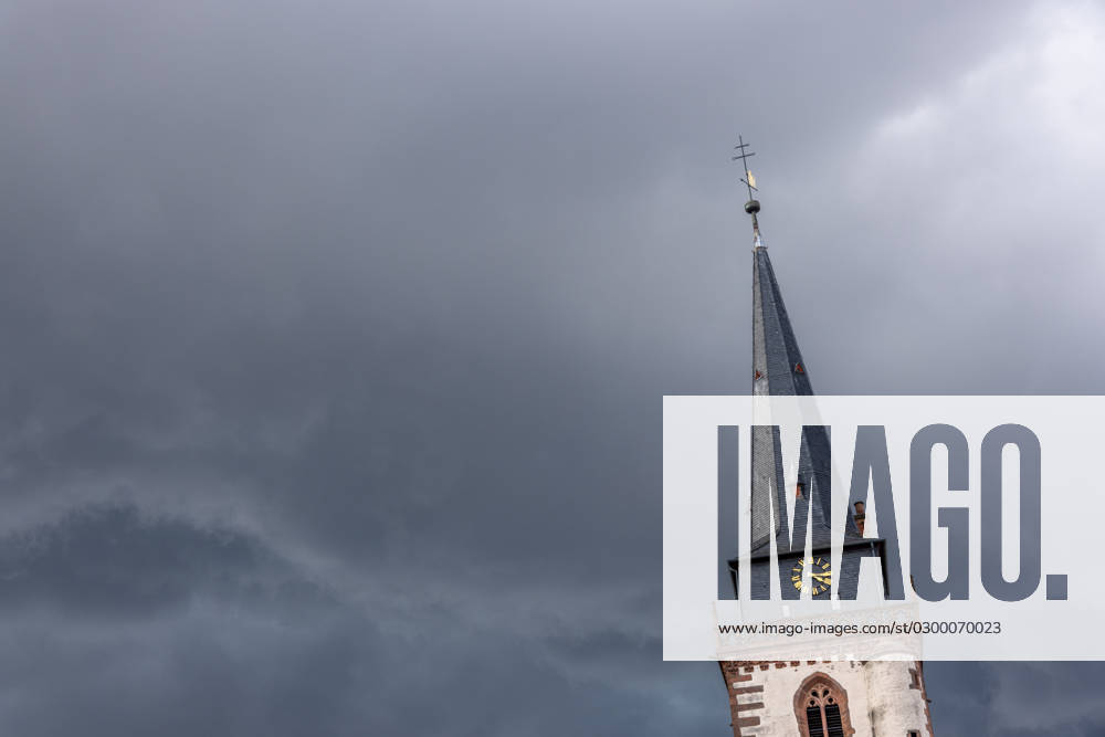 Dunkle Wolken über dem Kirchturm Dunkle Wolken eines Gewitters sind am Nachmittag am Himmel über dem Turm der katholischen Kirche St. Ursula zu sehen., Oberursel Hessen Deutschland