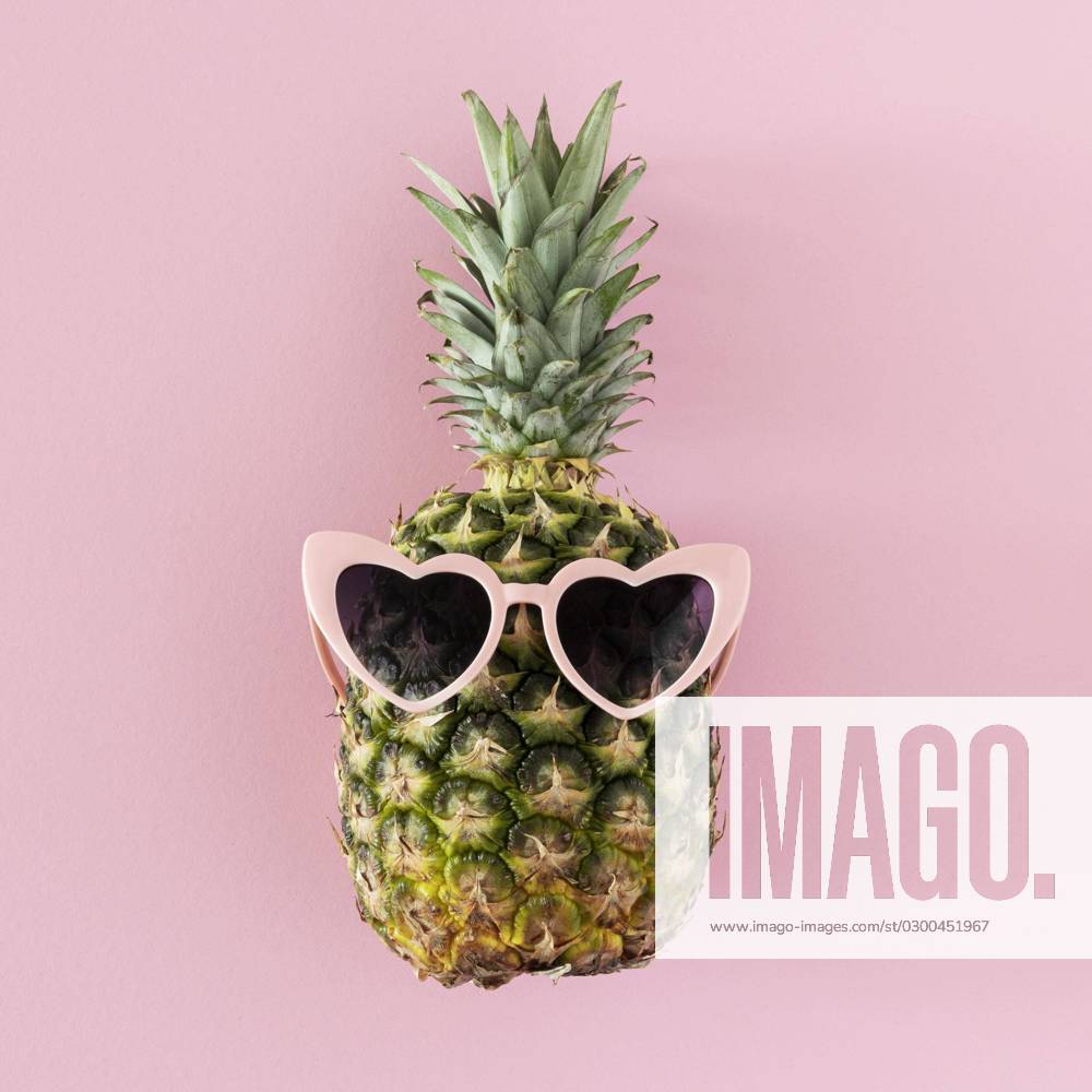 Draufsicht Ananas mit herzförmiger Sonnenbrille. Schönes Foto