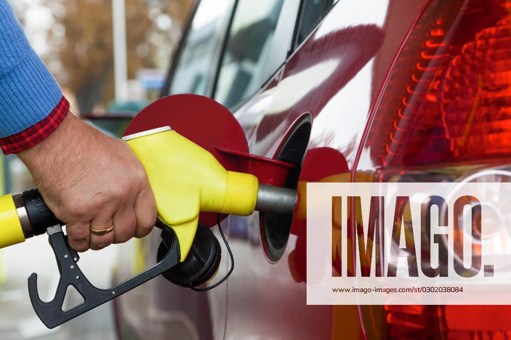 Frau beim tanken auf Tankstelle Eine junge Frau Tankbenzin auf einer Tankstelle. Die Kosten für das Auto werden wegen der Benzinpreise immer teurer ,model released, Symbolfoto