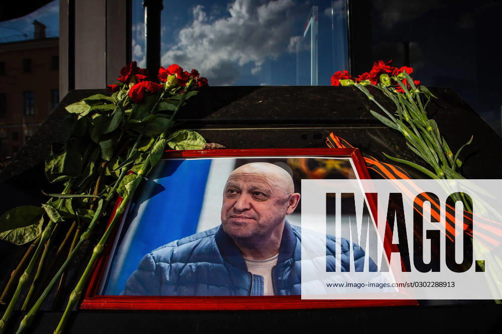 A portrait of Yevgeny Prigozhin, head of the private military company Wagner, and flowers laid in his memory at a cafe on Universitetskaya Embankment in St. Petersburg, which belongs to him. On Wednesday, August 23, the Federal Air Transport Agency confirmed in a statement the death of 10 people who were on board a business jet belonging to businessman and founder of Wagner PMC Yevgeny Prigozhin, which crashed in the Tver region, Russia. The Federal Air Transport Agency also confirmed that Yevgeny Prigozhin was on the list of 10 people on board, among whom 3 were crew members. Also on this list was Prigozhin s right hand, Dmitry Wagner Utkin. The Investigative Committee of Russia has launched a- ZUMAs197 20230825_aaa_s197_133
