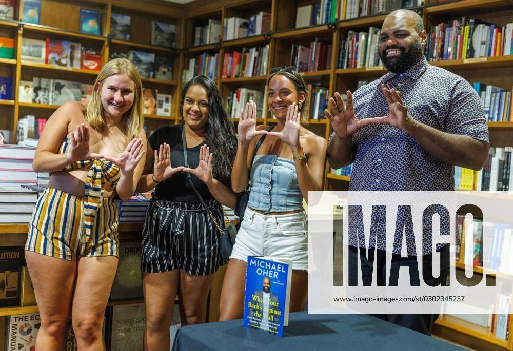 Author Michael Oher does the U with UM law students from left- Megan Nubauer, Sharmila Singh and Megan Williams after autographing his book titled, When Your Back s Against the Wall: Fame, Football, and Lessons Learned through a Lifetime of Adversity, for them at Books & Books in Coral Gables on Wednesday, Aug. 23, 2023. - ZUMAm67_ 20230824_zaf_m67_050