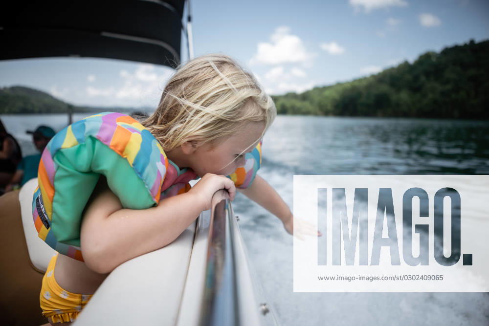 IMAGO Creative, Jahreszeit Sommer, Sommerferien Young child leaning over boat railing to touch wake on lake Cookeville, Tennessee, United States CR_WEKW23082878-1242351-01 ,model released, Symbolfoto