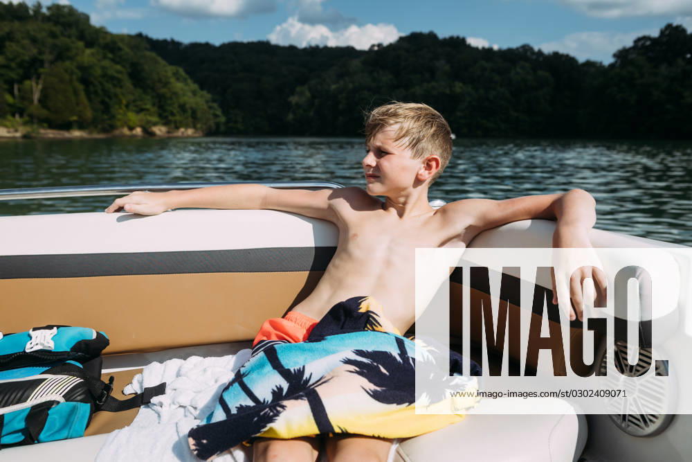 IMAGO Creative, Jahreszeit Sommer, Sommerferien Young boy sitting on pontoon boat during summer on sunny day on Cookeville, Tennessee, United States CR_WEKW23082878-1242356-01 ,model released, Symbolfoto