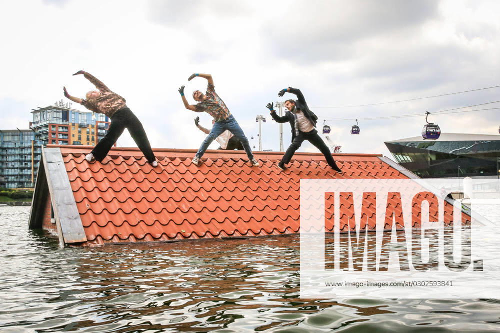 Sliding Slope performance by Vloeistof at Royal Docks, London, UK London, UK, 02nd Sep 2023. Performers from Dutch group Vloeistof present Sliding Slope a performance immersed in the water at Royal Docks, part of Greenwich+Docklands International Festival. Four people fight for survival on the rooftop of a submerged house. Inspired by the North Sea Flood of 1953, bringing a devastating historical disaster up to date in the face of rising sea water levels and global warming., Credit:Imageplotter Avalon