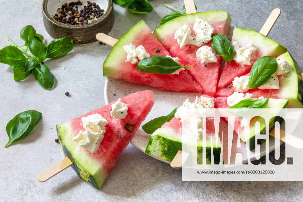 Healthy seasonal dieting and nutrition, summer snack. Watermelon pizza with feta cheese and basil on a gray stone tabletop. Healthy seasonal dieting and nutrition, summer snack. Watermelon pizza with feta cheese and basil on a gray stone tabletop.