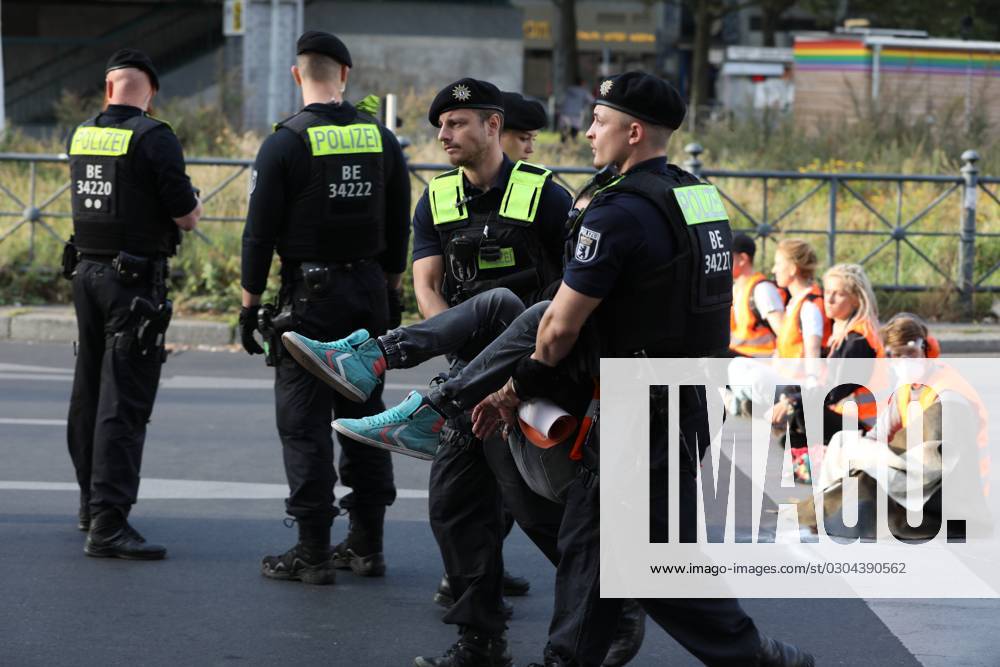 Berlin, Deutschland, 18.09.2023: Protest von Klimaaktivisten der Letzten Generation am Kottbusser Tor in Berlin-Kreuzberg. Polizisten tragen einen abgelösten Aktivisten weg.