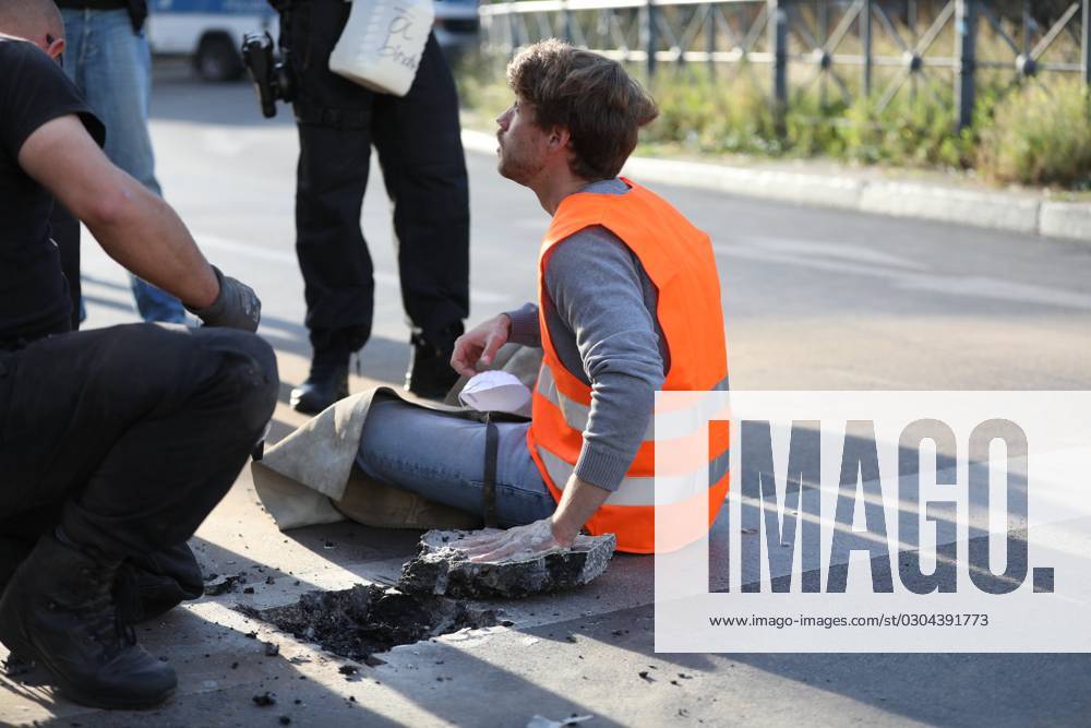 Berlin, Deutschland, 18.09.2023: Protest von Klimaaktivisten der Letzten Generation am Kottbusser Tor in Berlin-Kreuzberg. Polizisten lösen einen anbetonierten Aktivisten von der Straße.