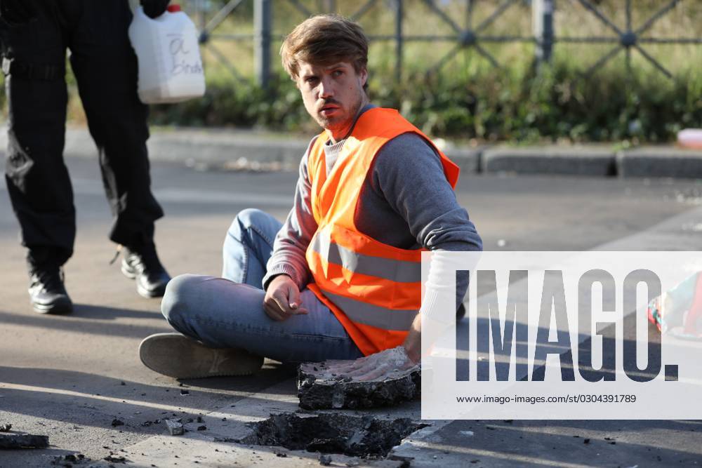 Berlin, Deutschland, 18.09.2023: Protest von Klimaaktivisten der Letzten Generation am Kottbusser Tor in Berlin-Kreuzberg. Polizisten lösen einen anbetonierten Aktivisten von der Straße.
