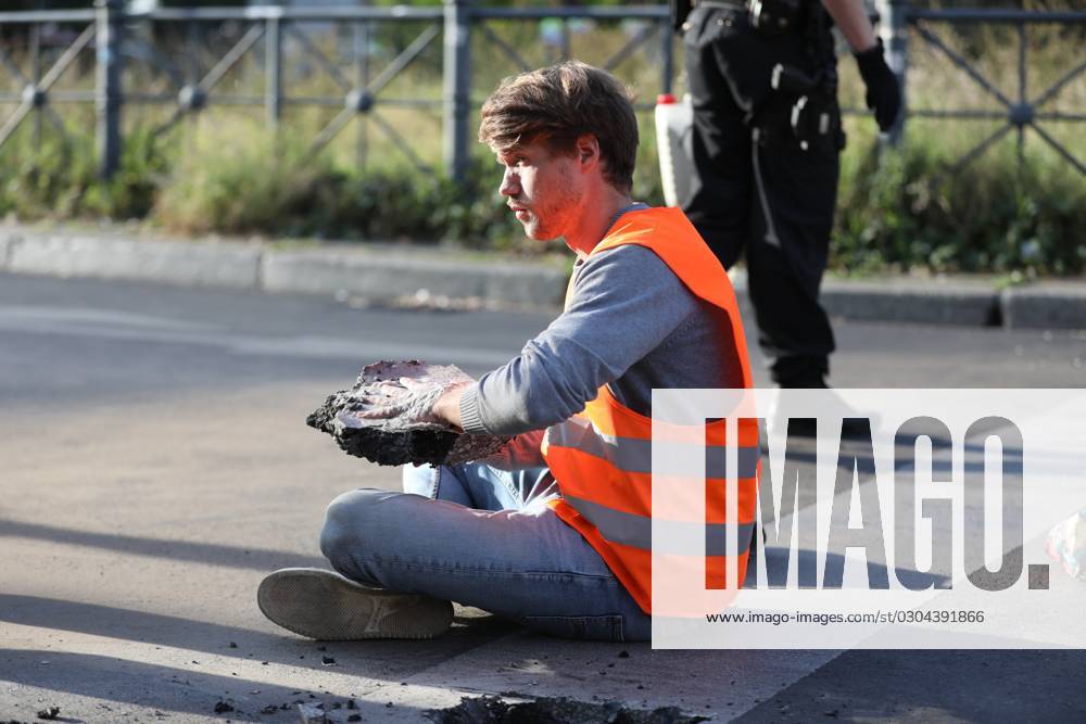 Berlin, Deutschland, 18.09.2023: Protest von Klimaaktivisten der Letzten Generation am Kottbusser Tor in Berlin-Kreuzberg. Polizisten lösen einen anbetonierten Aktivisten von der Straße.