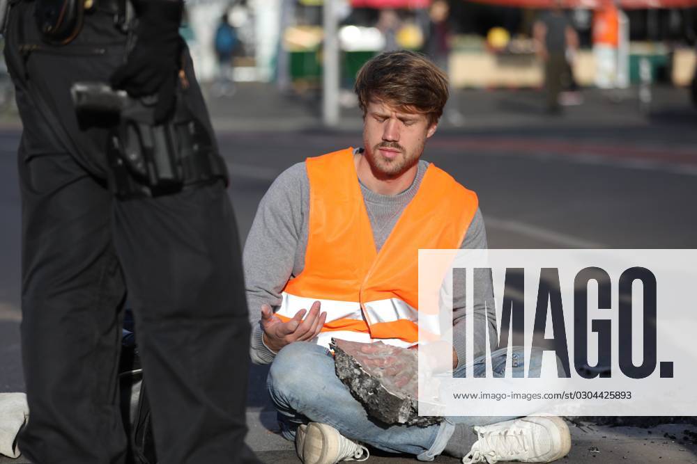 Berlin, Deutschland, 18.09.2023: Protest von Klimaaktivisten der Letzten Generation am Kottbusser Tor in Berlin-Kreuzberg. Polizisten lösen einen anbetonierten Aktivisten von der Straße.