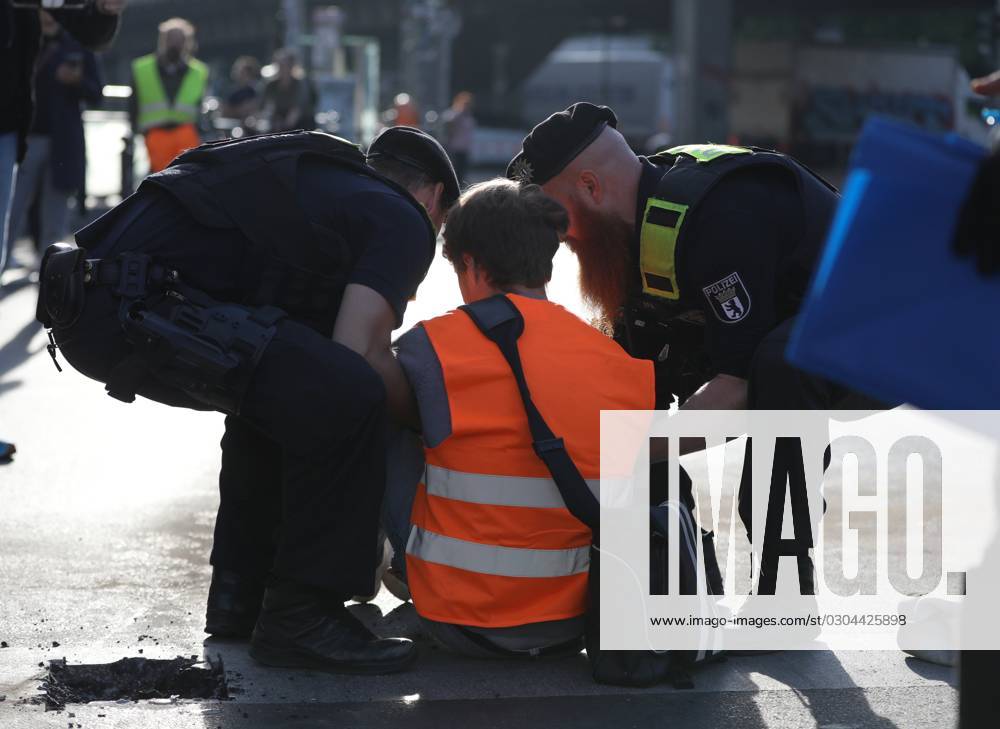 Berlin, Deutschland, 18.09.2023: Protest von Klimaaktivisten der Letzten Generation am Kottbusser Tor in Berlin-Kreuzberg. Polizisten tragen abgelöste Aktivisten weg.