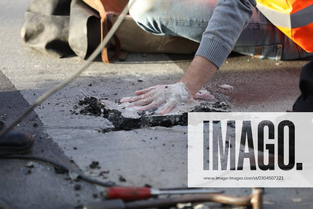 Berlin, Deutschland, 18.09.2023: Protest von Klimaaktivisten der Letzten Generation am Kottbusser Tor in Berlin-Kreuzberg. Polizisten lösen einen anbetonierten Aktivisten von der Straße.