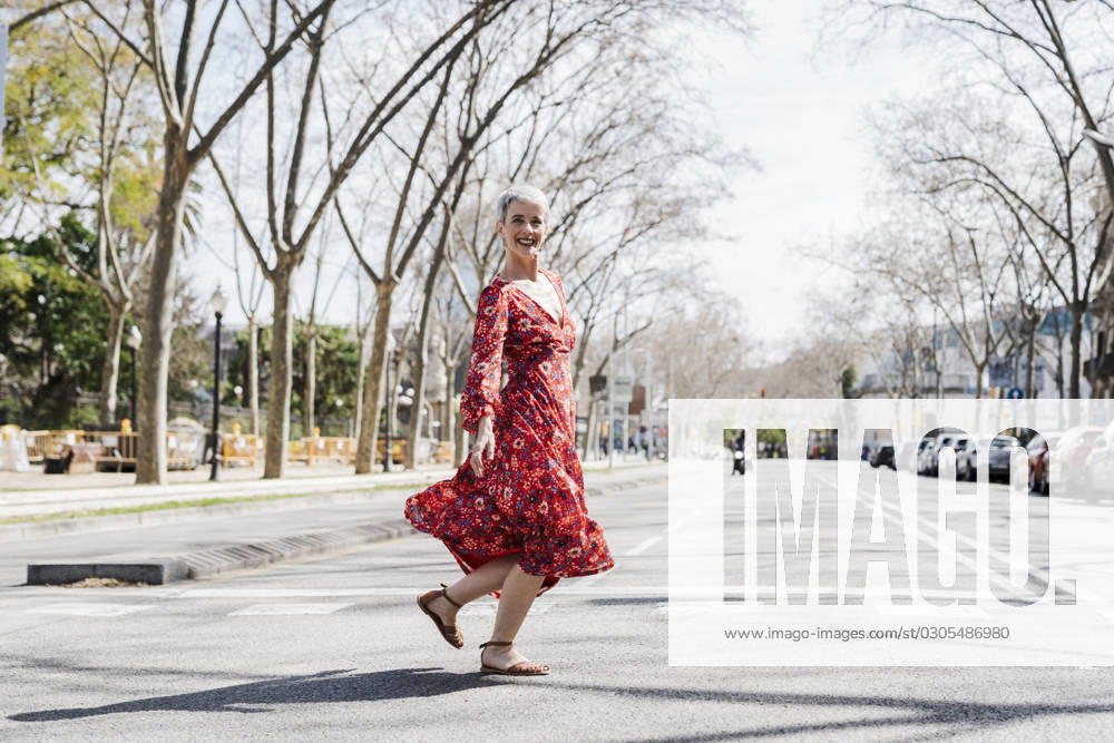 Smiling woman dancing on street in city model released, Symbolfoto, JCZF01261
